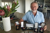 Robert Cooper sitting at a table with five war service medals 