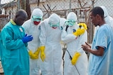 Red Cross workers pray before removing a body in Liberia