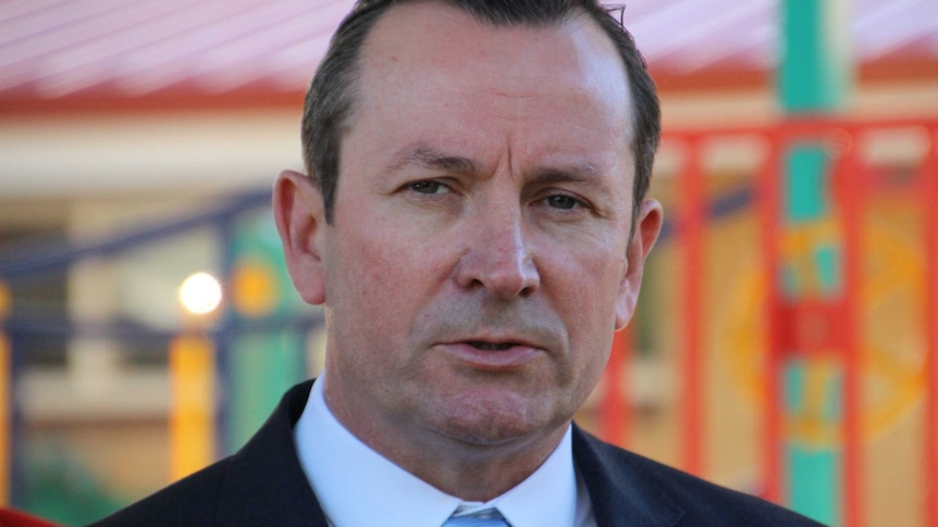 A close up photo of Premier Mark McGowan, with a playground in the background.