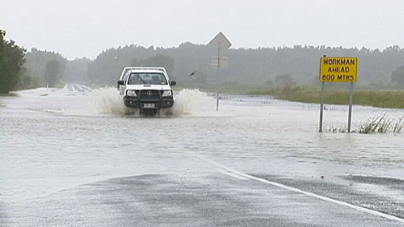 A four-wheel drive travels through a flooded highway in NSW
