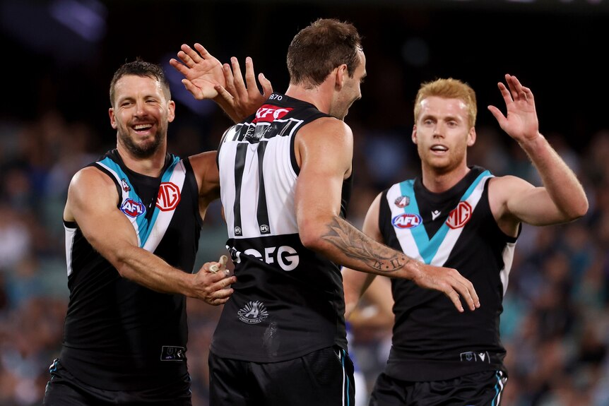 Port Adelaide players celebrate with Jeremy Finlayson
