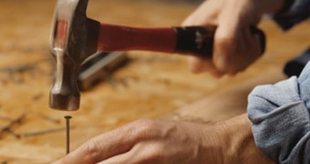 Unidentified man nailing with hammer