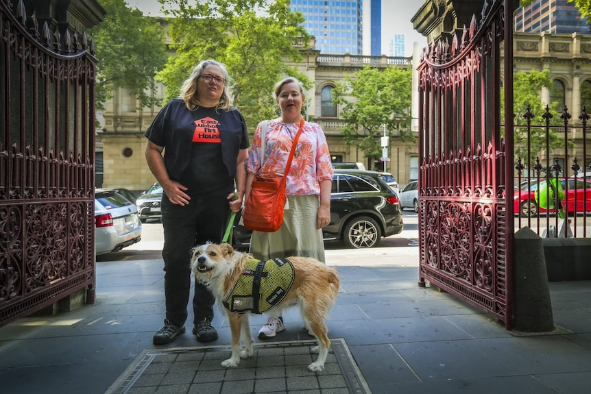 Clare Goss and Anthea Parsons with dog outside gates near court