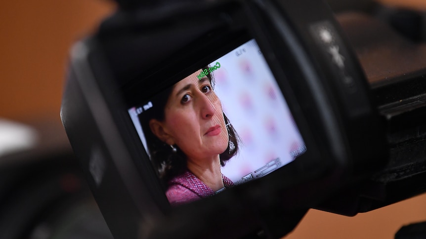 A close shot of Gladys Berejiklian is seen through the view finder on a television camera. 