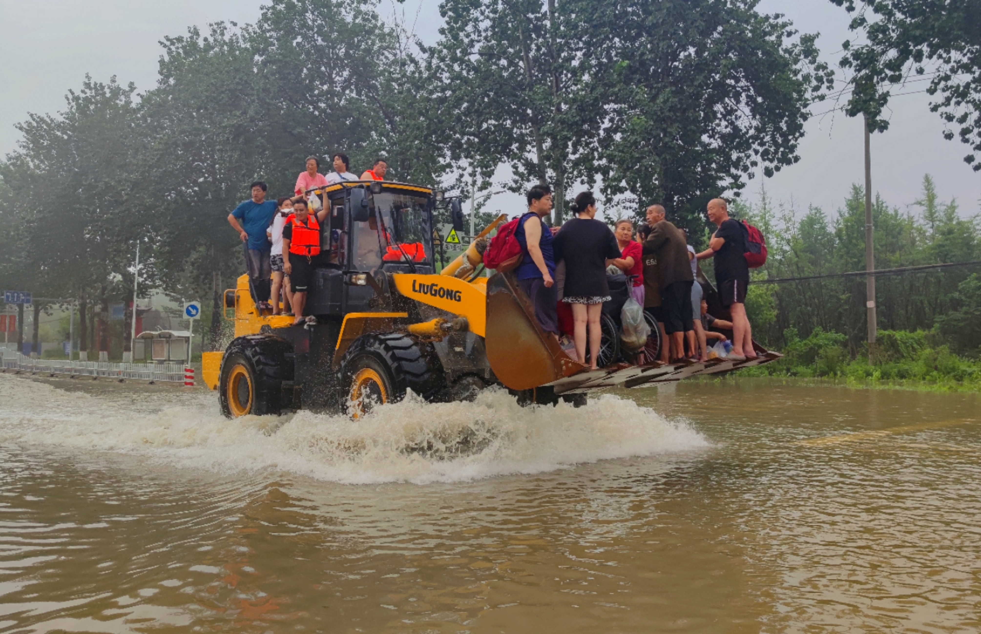 Local residents being evacuated on a forklift during China's flooding. 