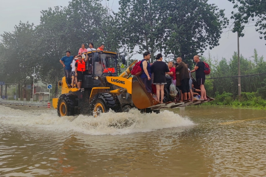 Local residents being evacuated on a forklift during China's flooding. 