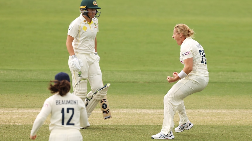 Katherine Brunt clenches her fists and yells in delight as Alyssa Healy looks disappointed