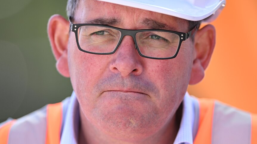 A close-up photograph of Daniel Andrews, with a hard hat slightly visible on his head and orange high-vis slightly visible.