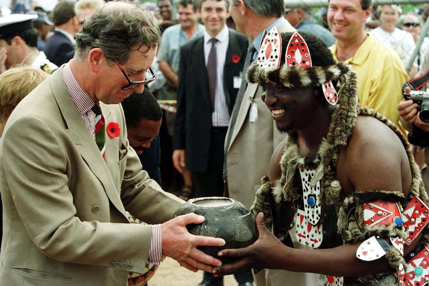 Prince Charles is presented with traditional sorghum beer by a local Zulu leader in South Africa.
