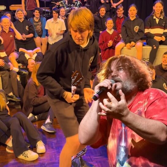 Students from Ringwood Secondary College rehearsing for the musical School of Rock, with Jack Black superimposed on the pic.