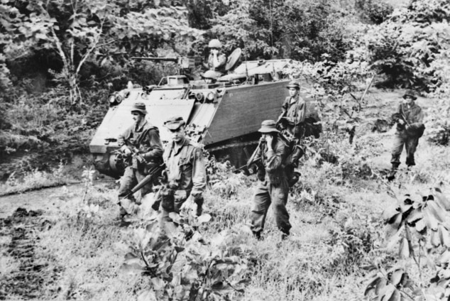 A tank and soldiers in jungle