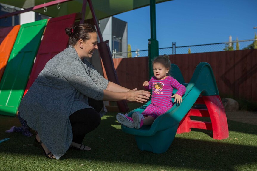 Miranda Edwards helps a child on the slide at Lulla's Children and Family Service in Shepparton, north-eastern Victoria.