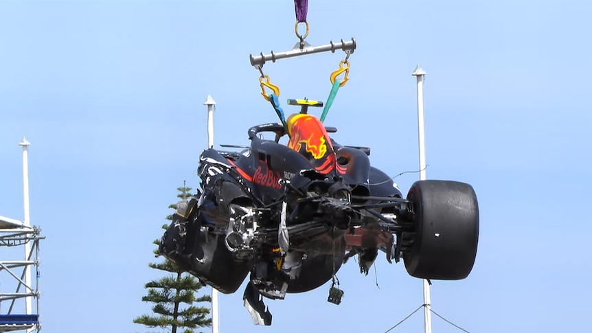 Wrecked F1 car lifted in the air after a crash