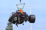 Wrecked F1 car lifted in the air after a crash