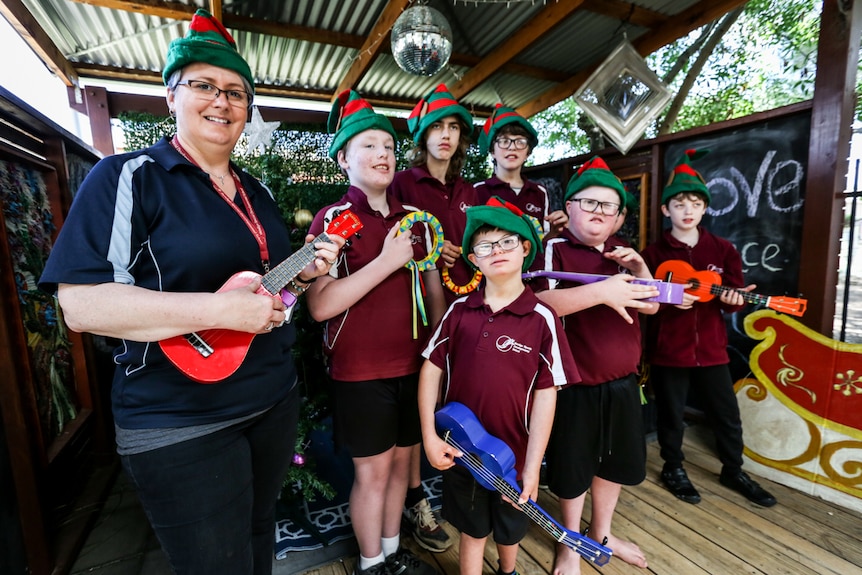 Kim Burns with her students dressed up in Christmas gear with her instruments.