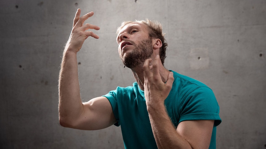 Performer Joel Bray has hands up while he theatrically performs