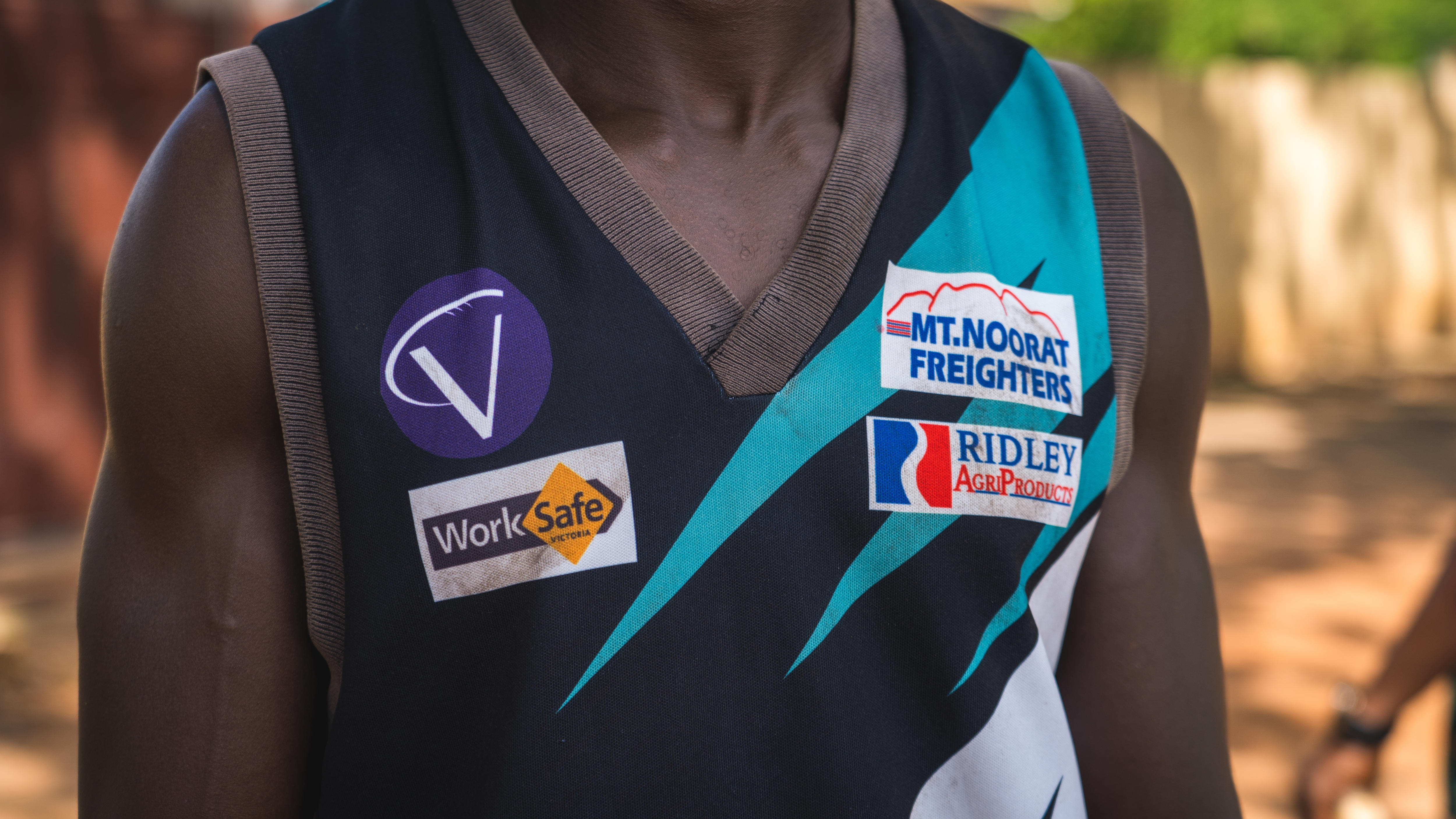 A man wears an AFL singlet.