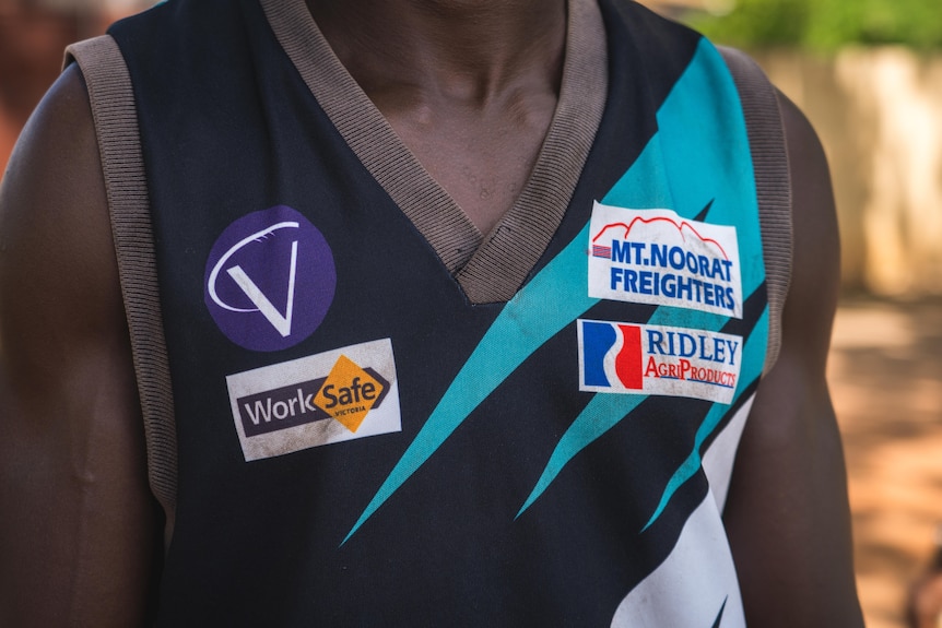 A man wears an AFL singlet.