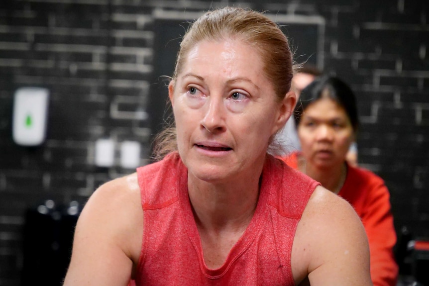 A close up of a woman working out on a stationary spin bicycle