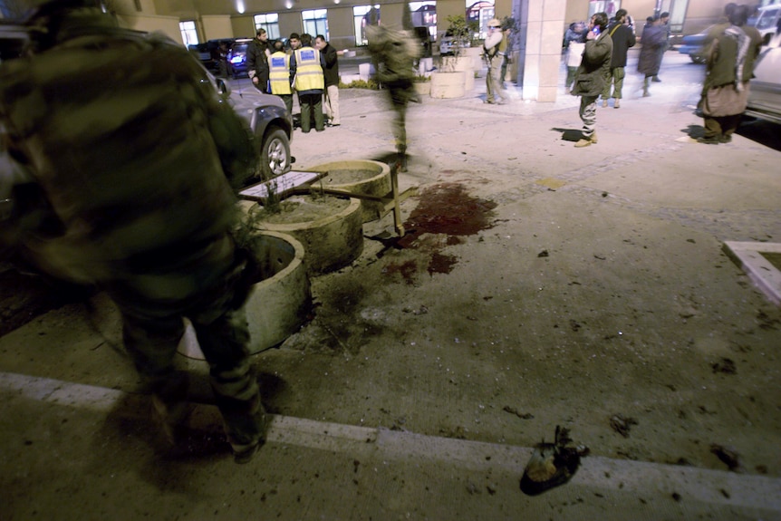 An image shows blood on the ground outside a building.