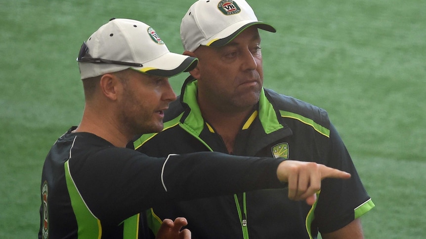 Australian team captain Michael Clarke speaks with coach Darren Lehmann during a training session.