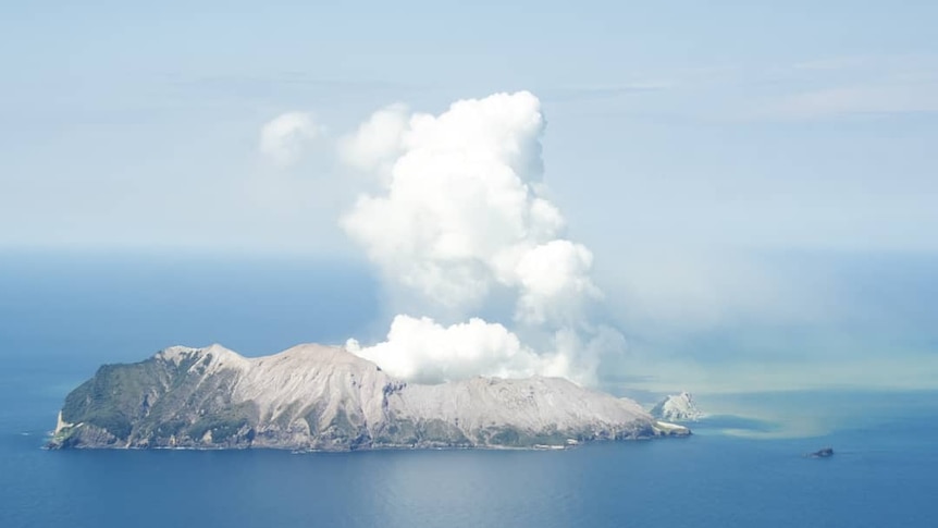 An island with plumes of smoke rising above it