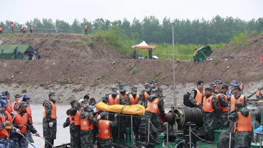 Rescue personnel move the remains of ferry victims