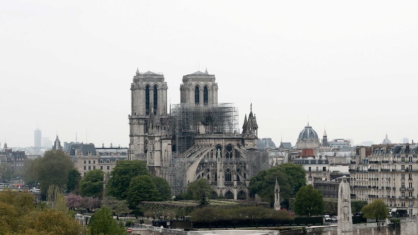 Notre Dame Cathedral seen from a distance with scaffolding surrounding fire damage