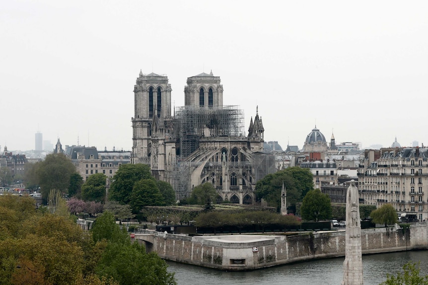 Notre Dame Cathedral seen from a distance with scaffolding surrounding fire damage