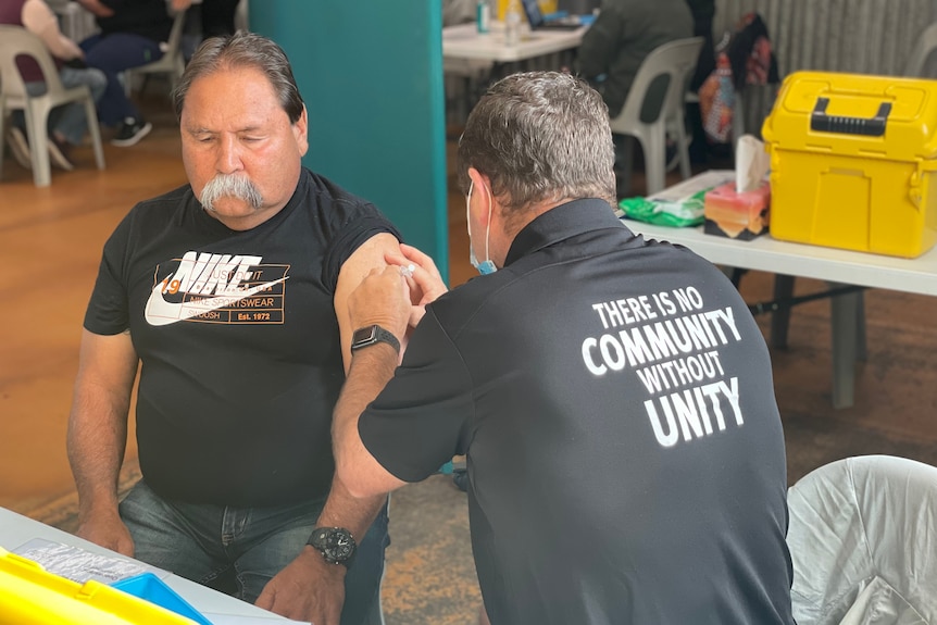 Uncle Bevan getting administered the Pzifer vaccine by Queensland health care worker at Cherbourg