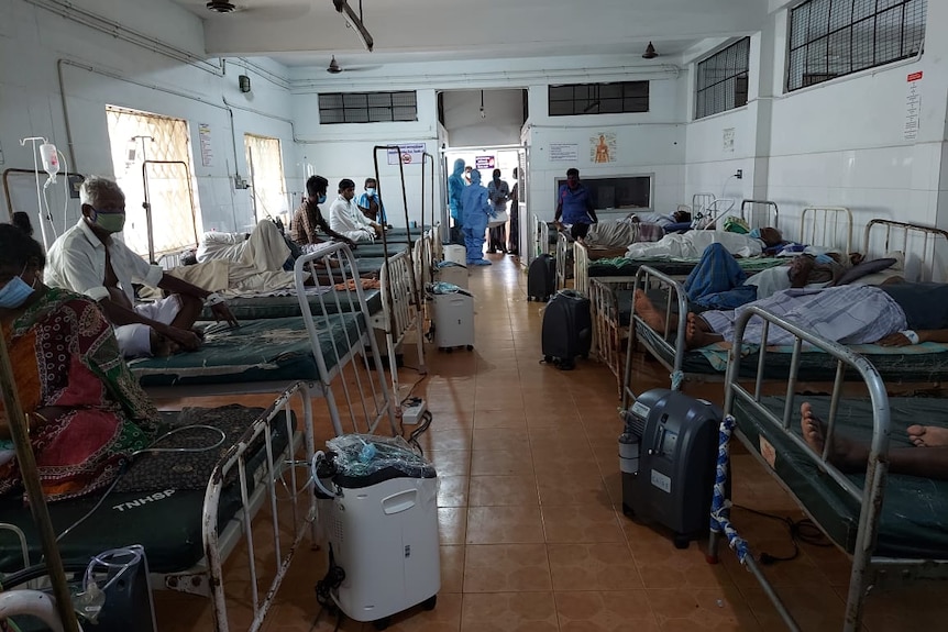 Oxygen machines on the floor in a ward filled with sick patients