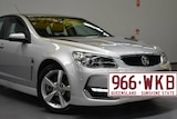 Generic image of a silver sedan, a Holden Commodore with a superimposed larger than life picture of a number plate.