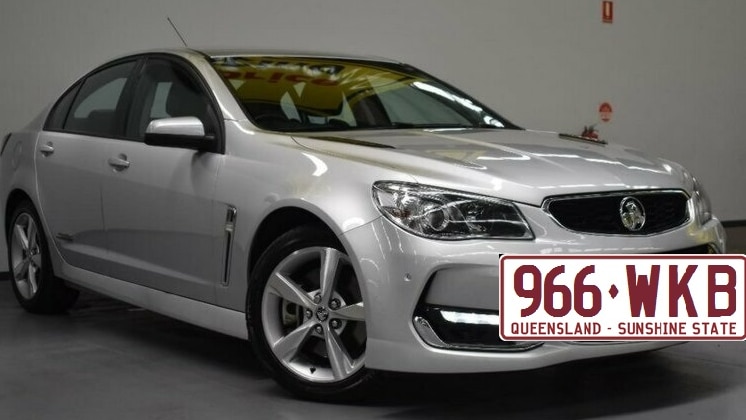 Generic image of a silver sedan, a Holden Commodore with a superimposed larger than life picture of a number plate.