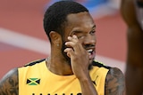 A Jamaican male sprinter touches his right eye at the World Athletics Championships.