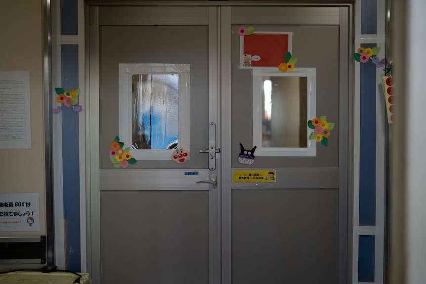 A hospital door covered in colourful cartoon stickers 
