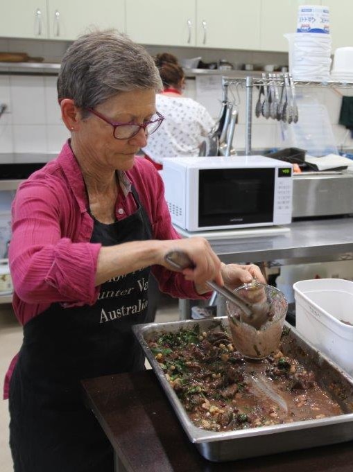 Volunteer Margaret Kavanagh dishing up meals for the disadvantaged in Amorelle’s café kitchen