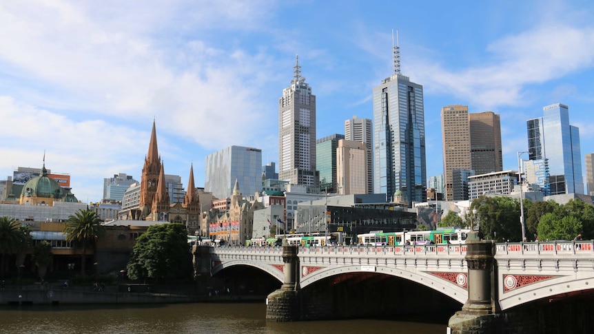 The Melbourne city skyline, looking over trams and the Princes Bridge.