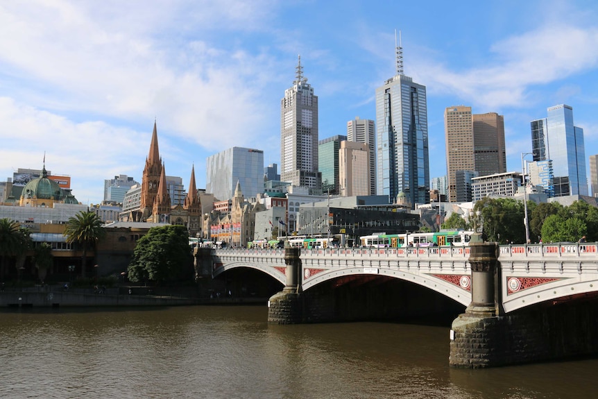 The Melbourne city skyline, looking over trams and the Princes Bridge.