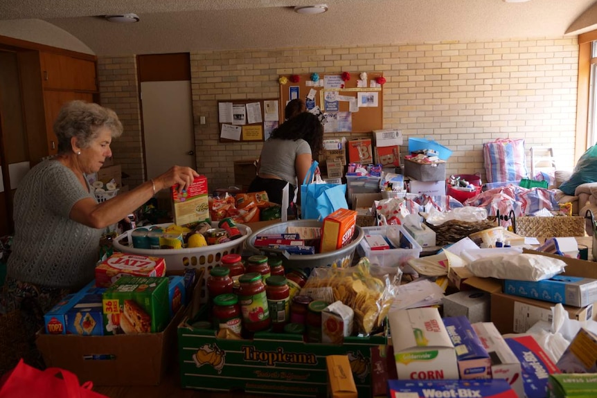 A woman packs a box of food