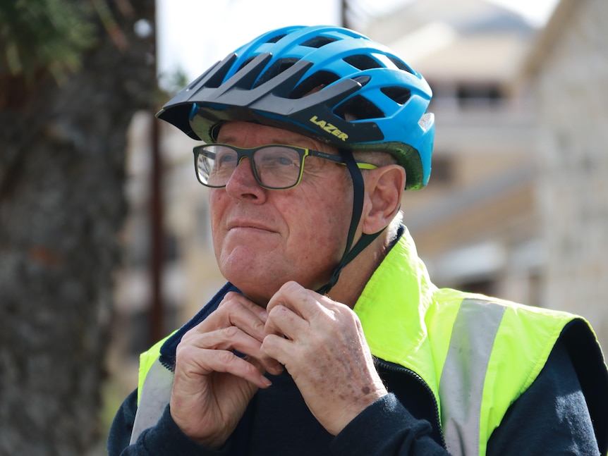 A close up of a cyclist doing up his helmet