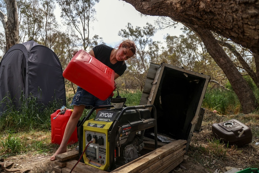 A woman using a jerry can to refill a petrol generator.