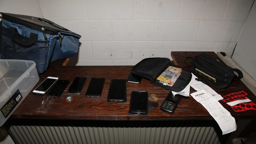 Mobile phones, money on table in Rebels OMCG club house