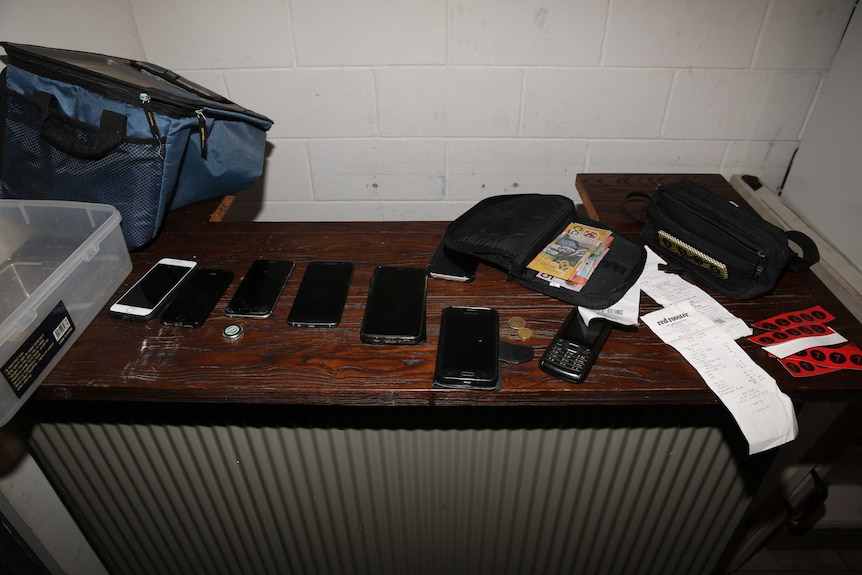 Mobile phones, money on table in Rebels OMCG club house