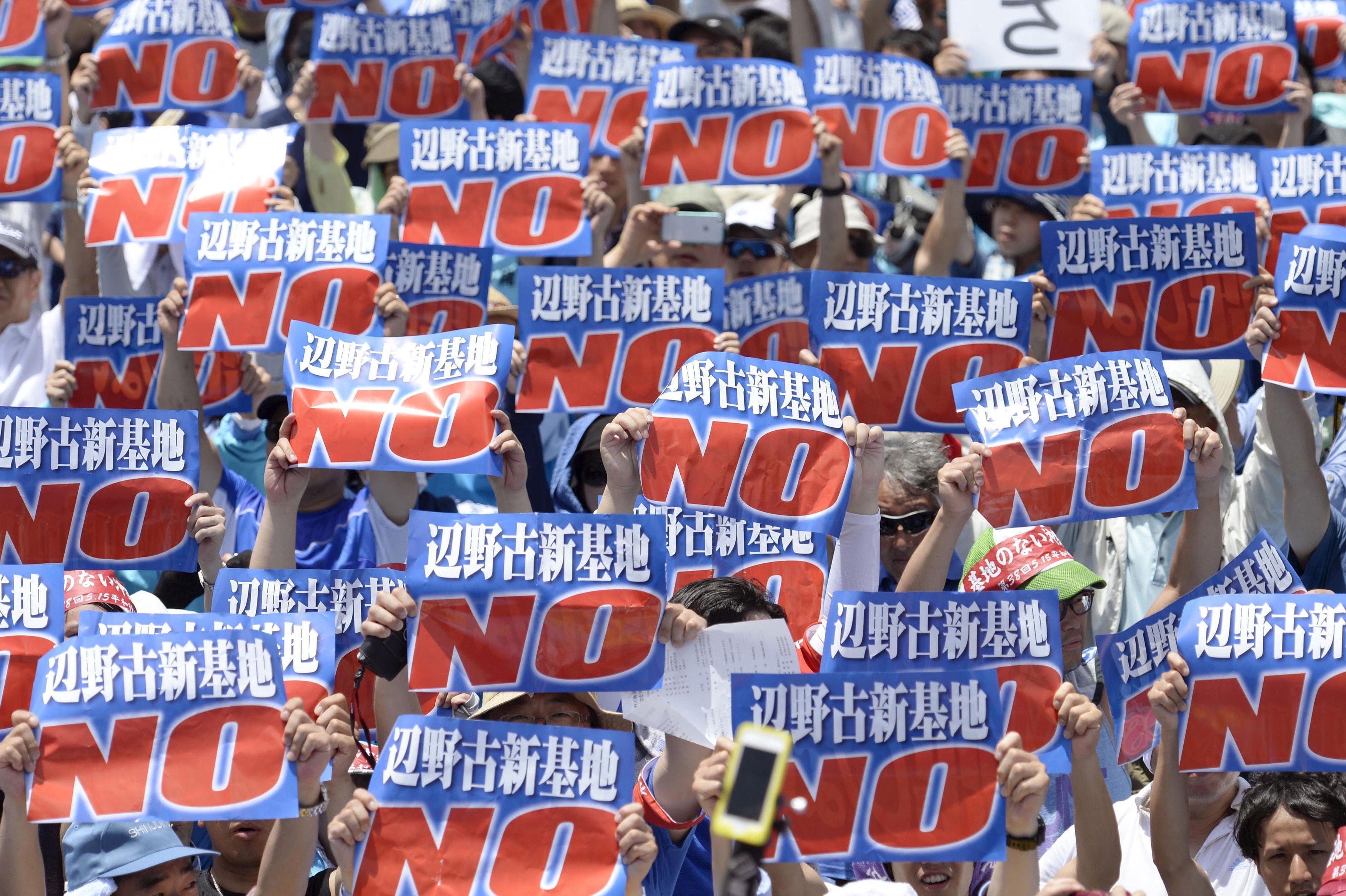 People hold up blue and red placards.