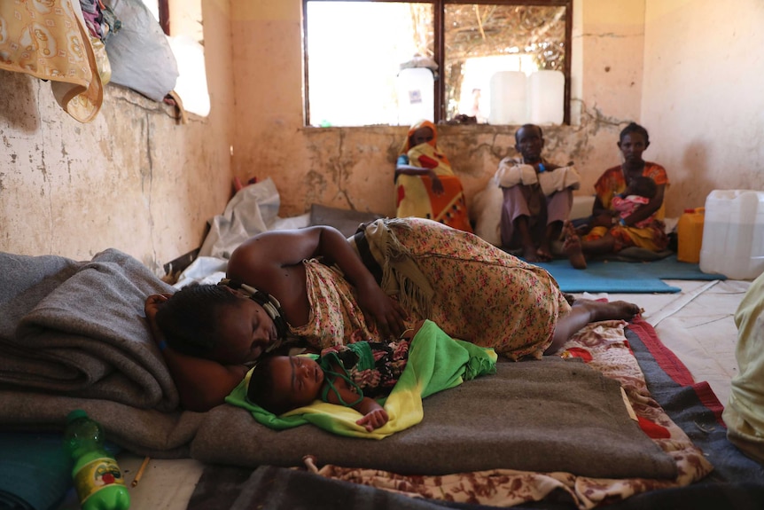 An Ethiopian mother and her child rest in a refugee shelter