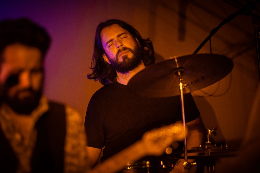 Drummer with eyes closed is clearly deep into the music