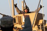 US Army soldier celebrates after crossing into Kuwait during the last convoy out of Iraq