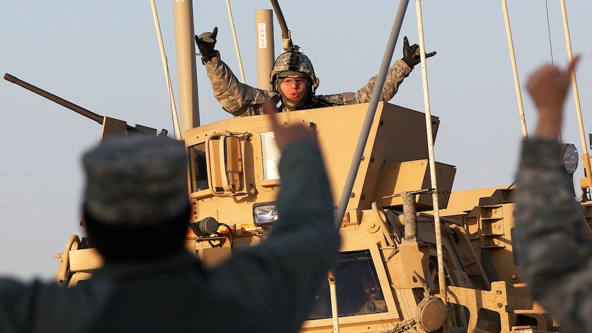 US Army soldier celebrates after crossing into Kuwait during the last convoy out of Iraq