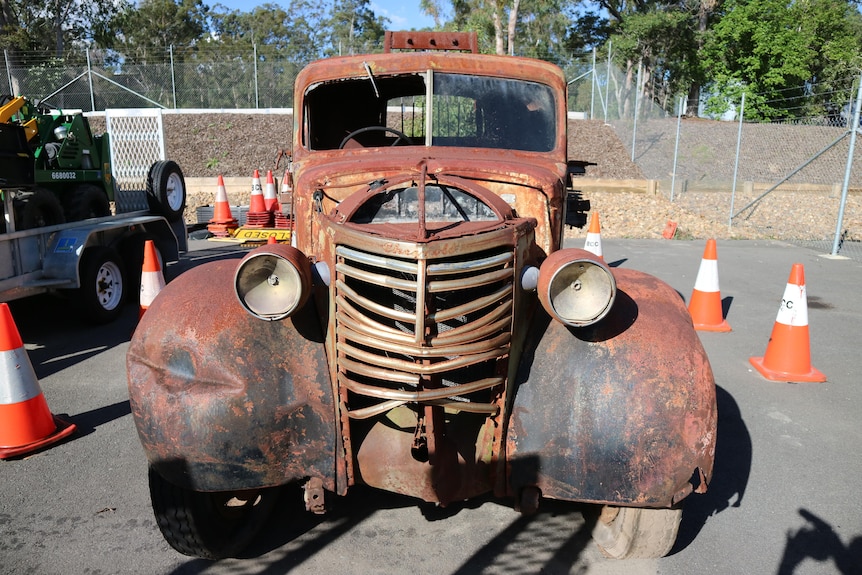 The front of a rusted, derelict Chevy truck.