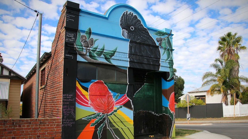 An art mural on a street corner building